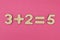 Simple arithmetic for children. Three plus two - equal to five on a bright pink background