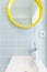 Simple bathroom with yellow mirror