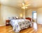 Simple bedroom with flowery bedding and hardwood floor.