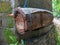 A simple bee hive made from bamboo trunk. Bamboo hive hanging on a blue string. Dark brick wall covered with tropical moss.