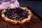 A simple blueberry pie on a wooden shelf. Homemade round cake. Sweet pastries, flour products cooked at home. Open pie with