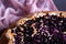 A simple blueberry pie on a wooden shelf. Homemade round cake. Sweet pastries, flour products cooked at home. Open pie with