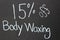 Simple chalk board sign with the sale on body waxing written on face of it