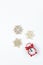 Simple Christmas composition. Small analog red clock, wooden snowflakes on white background. Minimal style flat lay, for social