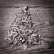 Simple Christmas tree arranged from sawdust, wood-chips on grey
