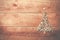 Simple Christmas tree arranged from sawdust, wood-chips on wooden background.