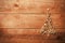 Simple Christmas tree arranged from sawdust, wood-chips on wooden background.