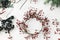 Simple Christmas wreath with red berries on rustic white background, flat lay