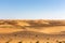 Simple desert landscape with golden sand dunes, crystal blue sky, copy space