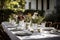 simple and elegant outdoor table setting with fresh flowers, white plates, and silverware