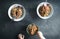 Simple family dinner, buckwheat vegan noodles with vegetables and beans, three plates and forks, child hands, top view