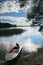 Simple fishers` motorboat, moored to the shore and view of the spaces of the lake Seliger under the blinding sunlight, Russia.