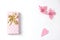 Simple flat lay composition. gift box of pink color with a bow of gold , a decoration in the form of a heart covered with a