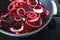 Simple food ingredients, red onion rings and slices of beetroot on pot on kitchen stovetop