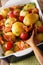 simple food: new potatoes baked with bacon and tomatoes in baking dish. vertical