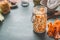 Simple fresh carrot cabbage salad in jars for healthy lunch is on kitchen table background, front view, with copy space.