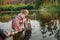 A simple girl washes things on an old washboard in a river in a forest. Retro art photo.