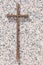 A simple gold memorial cross on a polished light pink granite slab, copy space