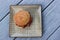 Simple gray wood background with patterned dish and breakfast sandwich