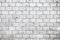 Simple grungy grey white brick wall with light and dark gray shades seamless pattern surface texture background. Wall weathered.