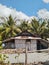 A simple house on the beach with some plants in front males the house more beautifull.