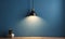 Simple lamp hangs on blue wall and illuminates it