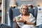 Simple living. Senior woman sitting alone on chair at home drinking tea or coffee enjoying her time and life. Older female