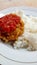A simple menu, rice with flour fried chicken and sambal or tomato chili sauce. Selective focus.
