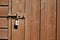 Simple metal code lock on a wooden brown color shed door. Safety and security concept. Peace of mind for the owner
