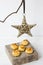 Simple minimalist Christmas decoration rattan star hanging on a dry tree branch, coconut macaroons on a wood box, white background