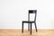 simple modern black chair on a wooden flor in front of white background