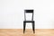 simple modern black chair on a wooden flor in front of white background