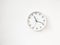 Simple modern round clock on white wall