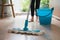 Simple mop on laminate floor with water bucket in background