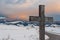 Simple oak catholic cross, curved asphalt road, snowy mountains