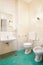 Simple, old bathroom with green tiled floor