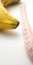 Simple Photo Conceptual Illustration for Penis Size, Banana with Pink Plastic Tailor meter on white background