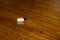 Simple pile of white pills, medicines, pills stacked on brown background