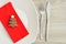 A simple place setting for Christmas consisting of a plate, fork, knife, red napkin and a chocolate shape christmas tree