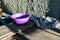 A simple purple plastic plate, outdoor tableware for feeding animals, cats and dogs, stands on dusty wooden planks