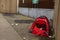 Simple red tent on a sidewalk of a street in a city. Homeless life in town. Social and poverty problem. Living in poverty