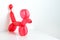 Simple red twisted balloon animal dog on white. Toy of balloons, free space for text. Balloon art.