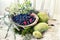 Simple rural still life. Wild berries in a wooden old dish , moss and various snags in the moss.