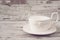 Simple rustic white crockery, empty dishes. A large cup of coffee in front angel. Wooden background, shabby chic, vintage