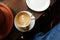 Simple serving of cappuccino coffee with heart shaped flower art on wooden table