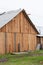 Simple shed built of wood. Green lawn, cloudy and gray sky