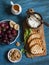 Simple snack - goat cheese, grilled bread, grapes, dry figs, walnuts, honey. On wooden background