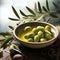 simple still life with bowl filled with olive oil and olives and leaves from olive tree as decortation