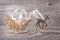Simple symbols of Father Christmas sleigh arranged from sawdust and reindeer made from dry wooden sticks on wooden grey background