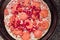 Simple uncooked pepperoni pizza with extra hot chilly pepper, on a metal round cooking tray. Close up. Selective focus. Italian